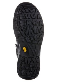 Suola di scarpa nera e robusta con profonde scanalature multidirezionali e un piccolo logo Vibram giallo vicino all'area dell'arco.