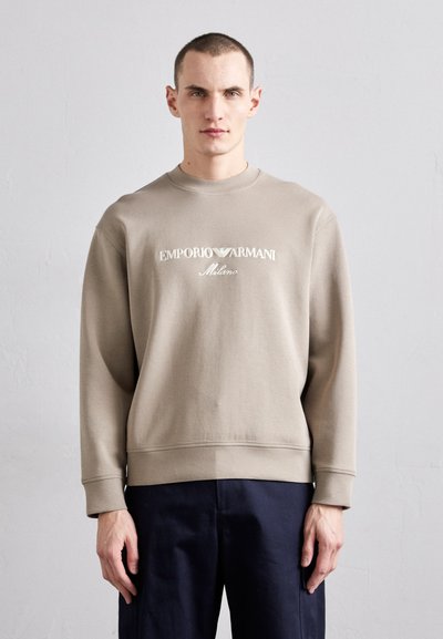 Sweatshirt beige en coton avec un col et des poignets côtelés, arborant le logo "EMPORIO ARMANI Milano" en broderie blanche sur le devant.