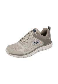 Zapatilla deportiva beige con material de malla y sintético; cuenta con cordones, suela acolchada y tira en el talón. Logotipo prominente en el lateral.