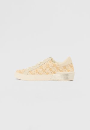 Beige sneaker met bloem borduursel, bovenwerk van textuurstof, ronde neus en metallic accent op de hiel. Vetersluiting.