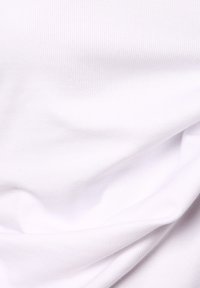 Witte ribbelstof met een gladde textuur, voorzien van fijne verticale lijnen. Zachte val met subtiele schaduwen en contouren. Geen opvallende accenten.