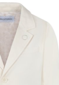 Blazer color crema con finitura satinata, chiusura a un bottone e un anello di accento argento. Presenta un rever a scollatura e una tasca sul petto.