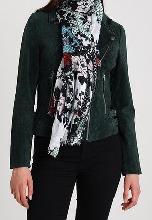 Veste biker en daim vert foncé avec des fermetures éclair et des accents de panneaux, associée à une écharpe blanche et noire à motif floral. Pantalon noir.
