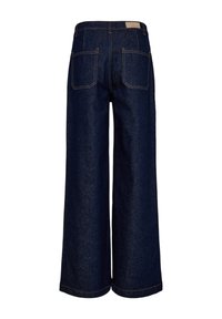Jean denim large à jambes larges bleu foncé avec taille haute, deux poches arrière et coutures contrastantes visibles.