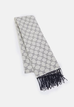 Écharpe gris clair pliée, avec un motif circulaire sombre répétitif et des franges noires à une extrémité, posée à plat sur un fond blanc.