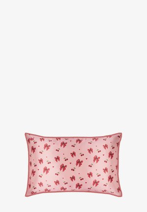 Cojín rectangular rosa con lazos rojos, cerezas y pequeños corazones, bordeado con ribete decorativo rojo.