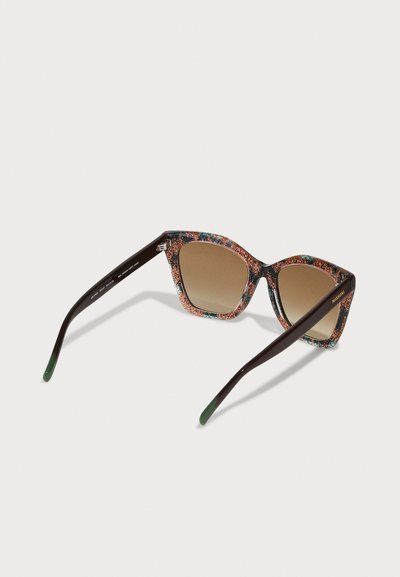 Sonnenbrille mit Katzenaugenform, gemustertem braunem Rahmen, braunen Gläsern und dunkelgrünen Akzenten an den Bügeln.