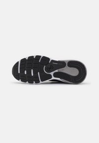 Schwarze Sportschuhsohle mit weißen Akzenten, die ein strukturiertes Griffmuster und Mesh-Details für Atmungsaktivität aufweist.