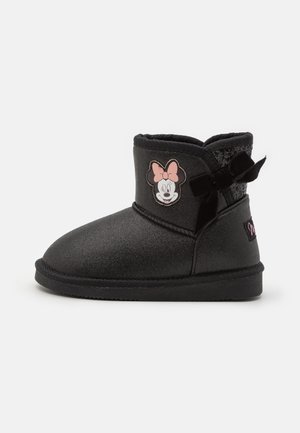 Czarny dziecięcy but z naszywką Myszki Minnie, różową kokardą i ozdobną czarną aksamitną kokardką po boku.