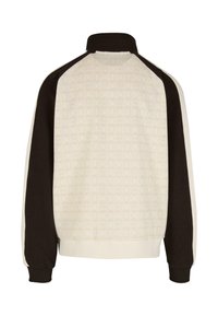 Pulover jakna z visokim ovratnikom, z vzorčasto kremno telo, temno rjave rokave in belimi stranskimi črtami. Material je iz mešanice bombaža.