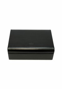 Boîte rectangulaire en cuir noir avec une texture lisse, des bords légèrement arrondis et un logo embossé simple sur la surface supérieure.