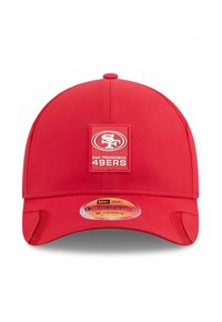 Casquette de baseball rouge avec une couronne arrondie, présentant une patch carrée avec "SF" et le logo des "San Francisco 49ers". Tissu doux et bandeau ajustable.