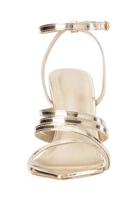 Gold strappy high-heeled sandal with ankle buckle, square toe, and three thin metallic straps across foot and toes.