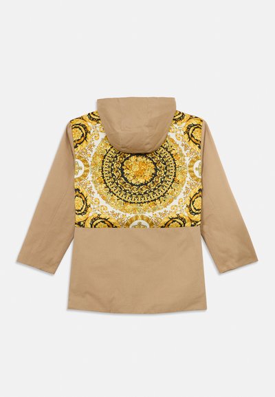 Καφέ άλλοτε μπουφάν με περίπλοκο κίτρινο και μαύρο λουλουδάτο και διακοσμητικό κυκλικό σχέδιο στο πάνω μέρος της πλάτης και στους ώμους.