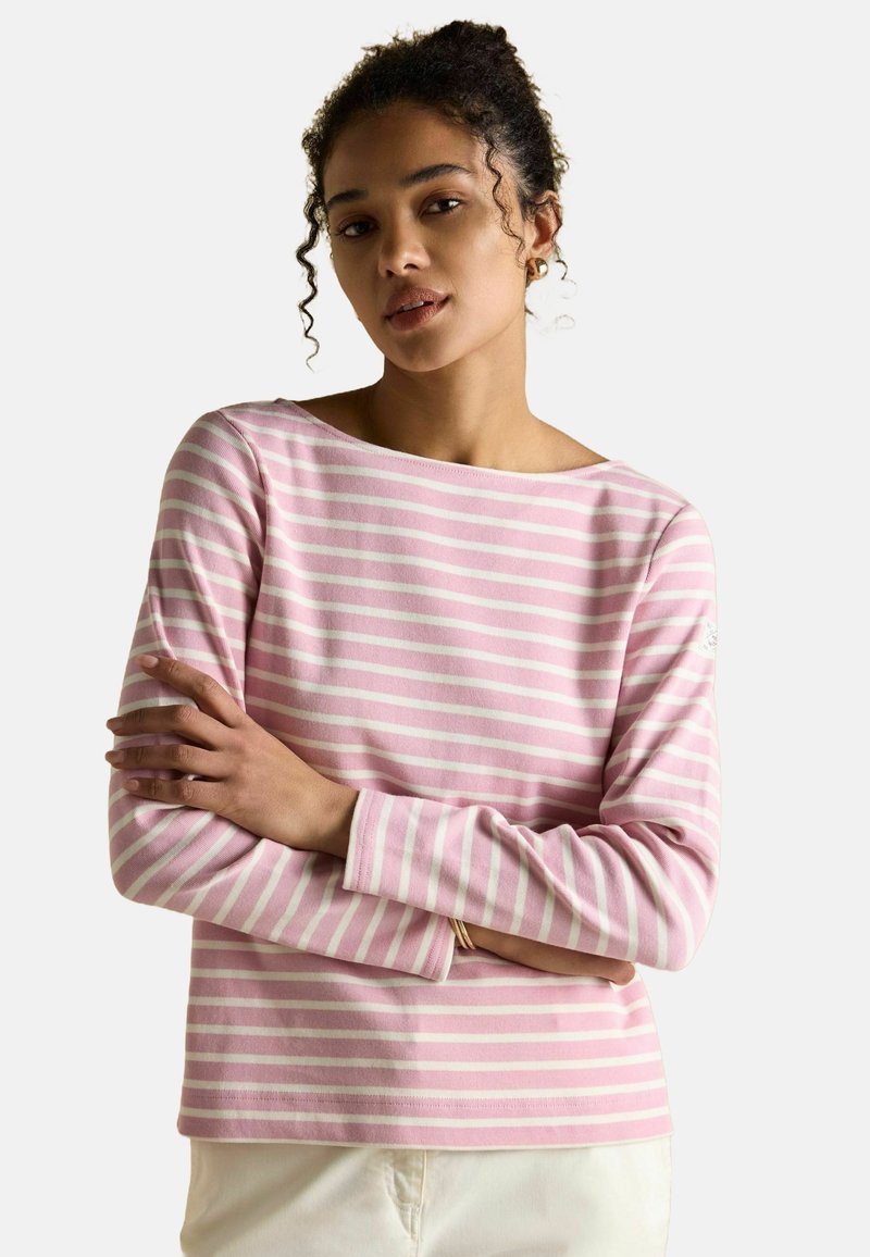 Długi rękaw bluzka w jasnoróżowym kolorze z białymi poziomymi paskami. Miękka tkanina, dekolt w łódkę i szyte mankiety. Prosty design bez ozdób.