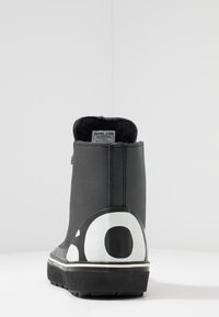 Czarne wodoodporne botki za kostkę o teksturowanym wykończeniu, czarnym wnętrzu i białym logo na podeszwie. Posiadają pętelkę ułatwiającą zakładanie.
