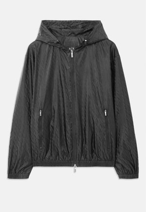 Casaco leve acolchoado preto com capuz, fecho frontal com zipper e dois bolsos laterais com zipper. Inclui punhos elásticos e bainha inferior.