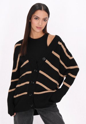 Black and beige striped cardigan with a V-neck, ribbed texture, oversized fit, and five buttons down the front.
