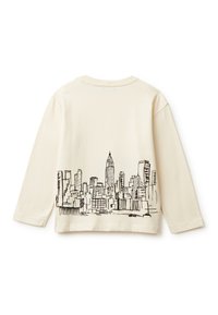 Kremowa koszula z długim rękawem z czarnym rysunkiem linii przedstawiającym panoramę miasta, w tym wyraźny, wysoki budynek, na plecach. Wykonana z materiału bawełnianego.