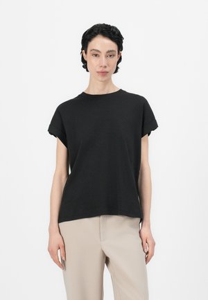 T-shirt preta de manga curta feita de algodão suave. Apresenta um corte descontraído com mangas enroladas e um decote redondo. Design simples e de cor sólida.