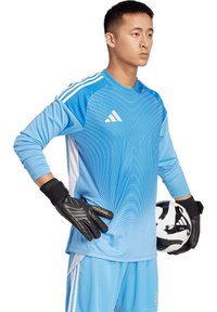 Maglia da portiere a maniche lunghe blu con motivo dinamico, guanti neri e pallone da calcio, con strisce bianche e accentuazioni del logo Adidas.