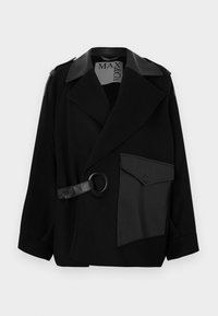 Čierny kabát z vlnenej zmesi s golierom zdobeným kožou, asymetrickým predným dielom, bočným vreckom a koženým remienkom s kovovým krúžkom.