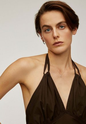 Top marrón sin mangas con un escote en V profundo, detalles fruncidos y una textura suave y ligera. Incluye collar de plata y pendientes de aro.