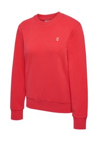 Czerwona bluza z miękkiego materiału, z okrągłym dekoltem i prążkowanymi mankietami. Biały logotyp w kształcie chevronu po lewej stronie klatki piersiowej.