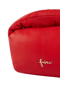 Červená kožená taška s křivkovým designem, s akcentem zlatého loga "faina" a viditelnými detaily šití. Měkká textura s strukturovaným tvarem.