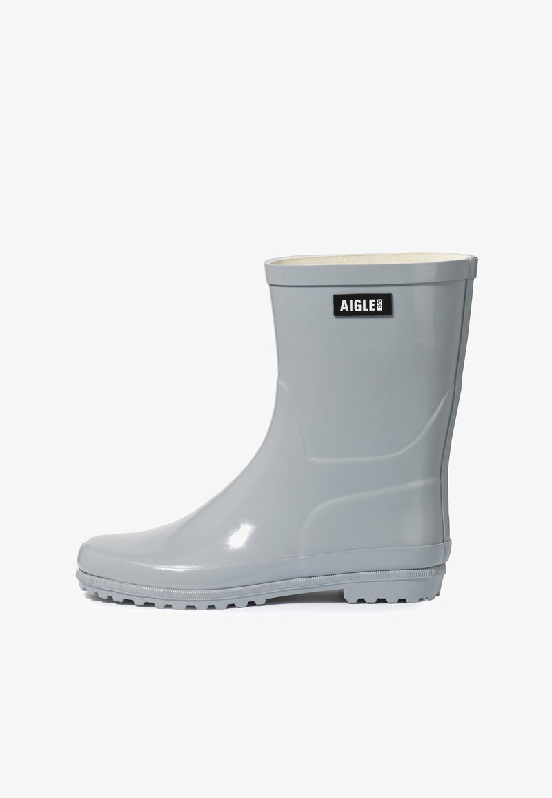 Botte de pluie en caoutchouc gris clair mi-mollet avec semelle texturée et écusson noir Aigle 1853 près du haut.