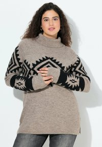 Beżowy oversized sweter z czarnymi geometrycznymi wzorami na rękawach, z ribbowanym golfem i bocznymi rozcięciami. Miękka tekstura, długie rękawy, luźny krój.