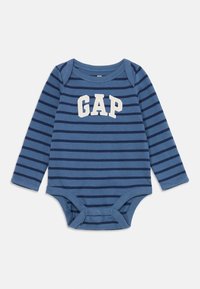 Mėlynas ir tamsiai mėlynas dryžuotas ilgomis rankovėmis kūdikių bodysuit'as su spaudėmis ir baltu "GAP" logotipu ant krūtinės.