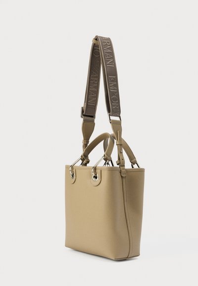 Μπεζ δερμάτινη τσάντα ώμου με υφή, διπλές χειρολαβές στην κορυφή και ρυθμιζόμενο ιμάντα με λογότυπο. Ασημένιες λεπτομέρειες μεταλλικών εξαρτημάτων.