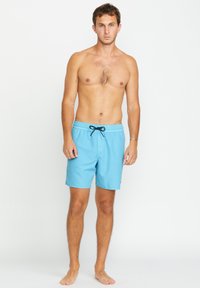 Un short de bain bleu clair en tissu lisse et à séchage rapide, doté d'une taille élastique avec un cordon noir et sans motifs visibles.