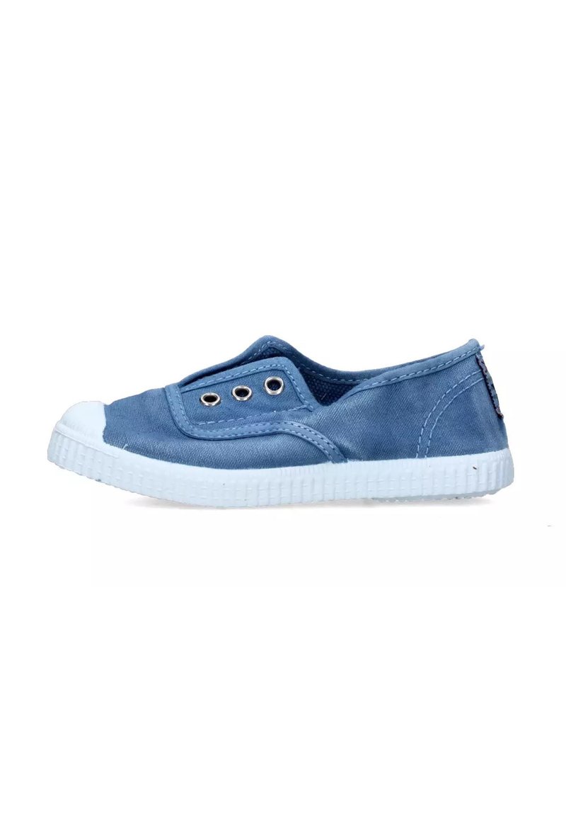 Scarpa slip-on in tela azzurro chiaro con punta in gomma bianca e suola bianca texturizzata, dotata di occhielli argentati per la ventilazione.