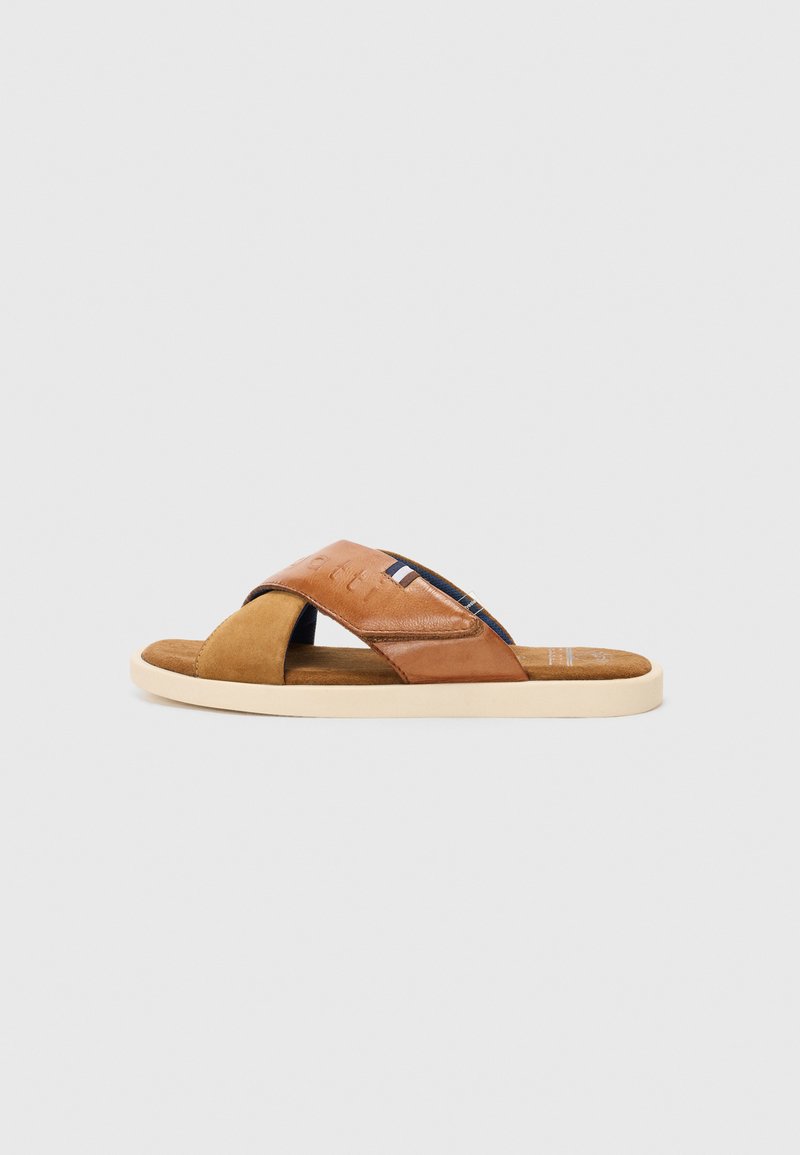 Sandale en cuir marron avec des lanières entrecroisées et une semelle intérieure en daim. Légère, avec une semelle en caoutchouc de couleur claire.