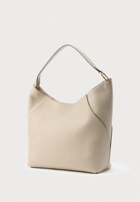 Bolso de hombro de cuero beige con un diseño sencillo, parte superior curva, una sola correa y herrajes en tono dorado en la unión de la correa.