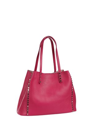 Roze leren shopper met dubbele schouderbanden en zilveren ronde studs langs de zijkanten op een witte achtergrond.