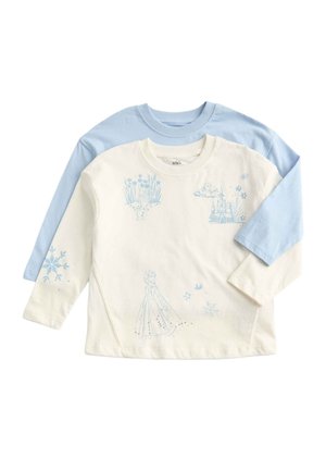 Dwa dziecięce topy z długim rękawem, jeden kremowy z niebieskimi wzorami zimowymi, a drugi gładki jasnoniebieski pod spodem.