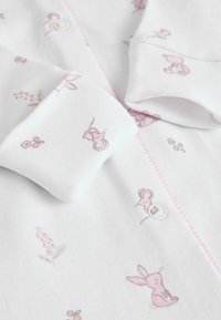 Bodies en coton blanc pour bébé avec des imprimés roses d'animaux et de fleurs, dotés d'un bouton et de délicates coutures roses à l'avant et aux poignets.