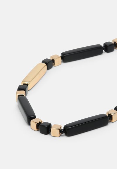 O brățară elegantă cu perle negre rectangulare alternative și perle aurii pătrate, aranjate într-un model geometric modern.