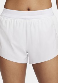 Baltos sportinės šortai su orui pralaidžia tinklelio juosmens dalimi, lygiu paviršiumi ir šoninėmis skeltukėmis judėjimo patogumui.
