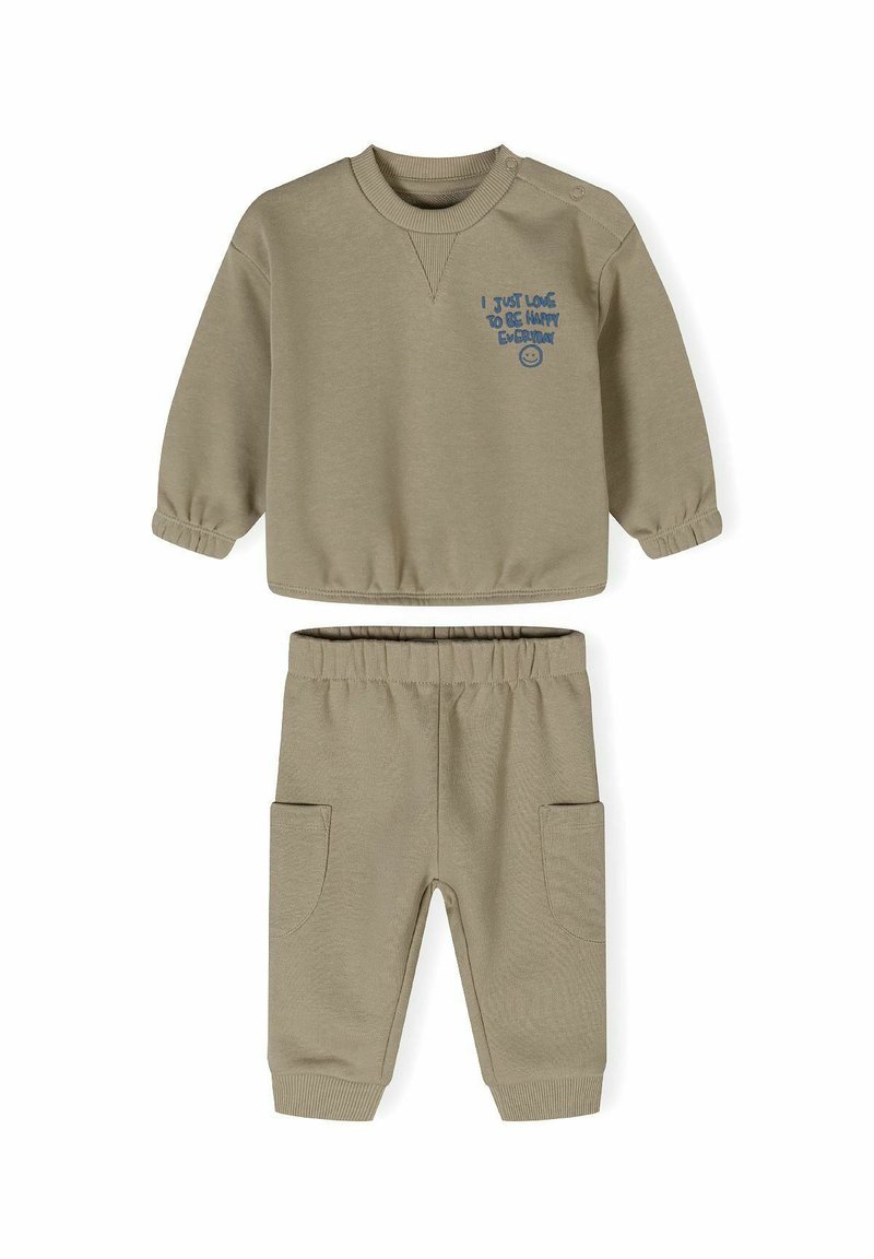 Ljus khaki tvådelad set med långärmad topp med rund halsringning och tryckknappar, samt byxor med elastisk midja och sidofickor.