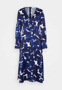 Robe à manches longues et col en V, avec un motif abstrait bleu, marine et blanc, et une taille cintrée, présentée sur un fond uni.
