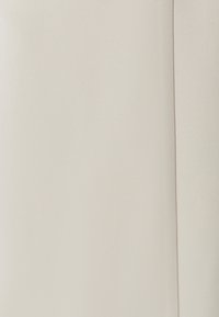 Light beige fabric showing a smooth texture with a matte finish. The material exhibits subtle hints of weave patterns and even color.