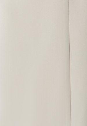 Tissu beige clair montrant une texture lisse avec une finition mate. Le matériau présente de subtils indices de motifs de tissage et une couleur uniforme.