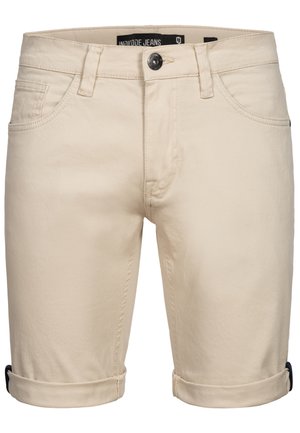 Beige denim shorts featuring a button closure, five pockets, rolled cuffs, and soft texture. Label shows brand name "Indicode Jeans."
