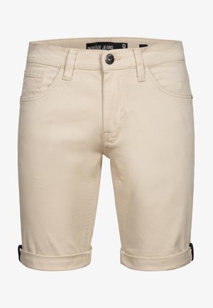 Beige denim shorts med knaplukning, fem lommer, opfoldede ben og blød tekstur. Etiket viser mærkenavnet "Indicode Jeans."
