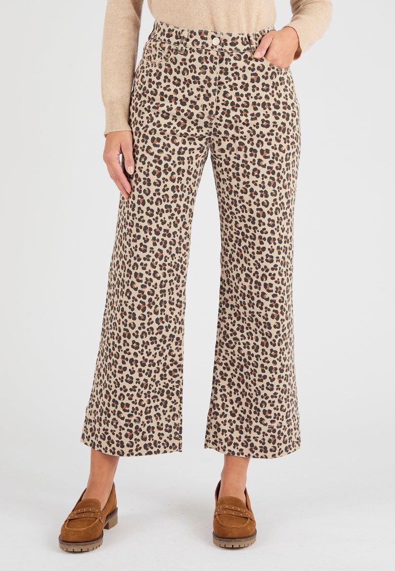 Pantalones de pierna ancha beige con un estampado de leopardo en negro y marrón, que cuentan con un cierre de botón en la parte delantera y bolsillos laterales.