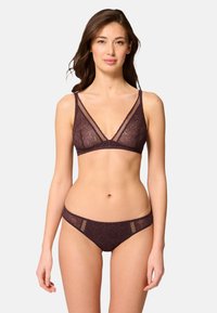 Burgundy spetsbralette med djup u-ringning och justerbara axelband, i kombination med matchande spetstrosor med genomskinliga sidopaneler.